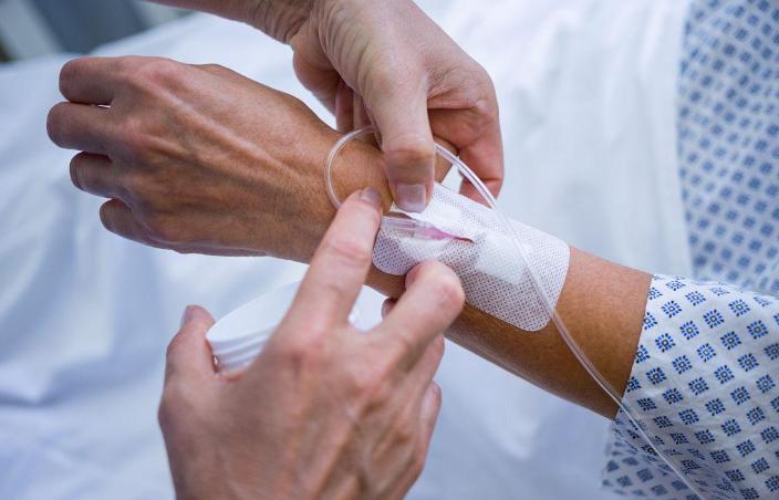 Nurse putting IV in patient's hand